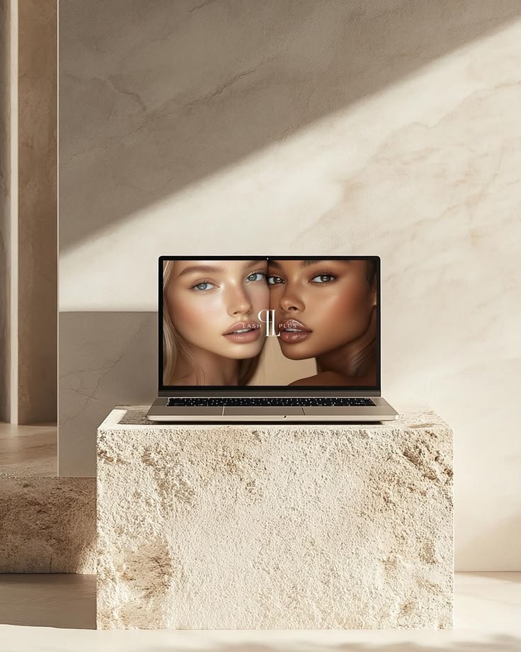 Mockup de un diseño de sitio web de la marca Lash Plus en una laptop sobre un bloque de mármol